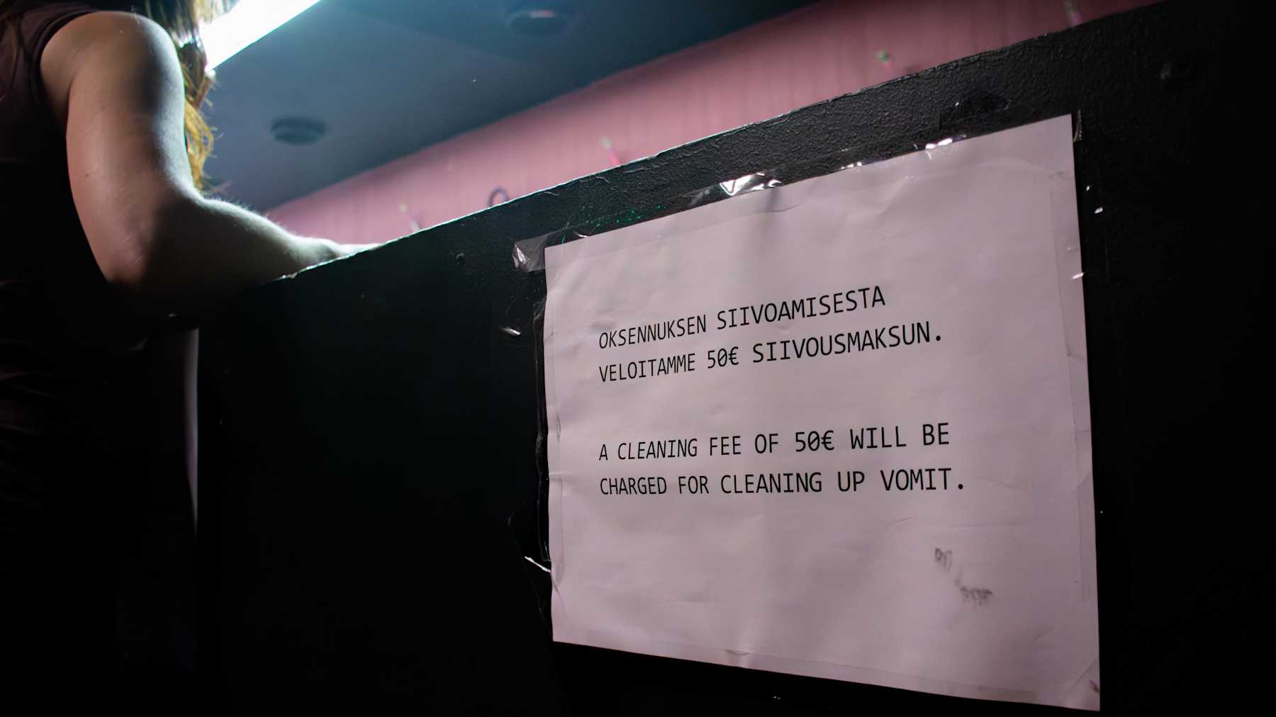 Hyvinkään Hopealyhty-yökerhon narikka, jossa on oksennuksien siivoamisesta kertova lappu.