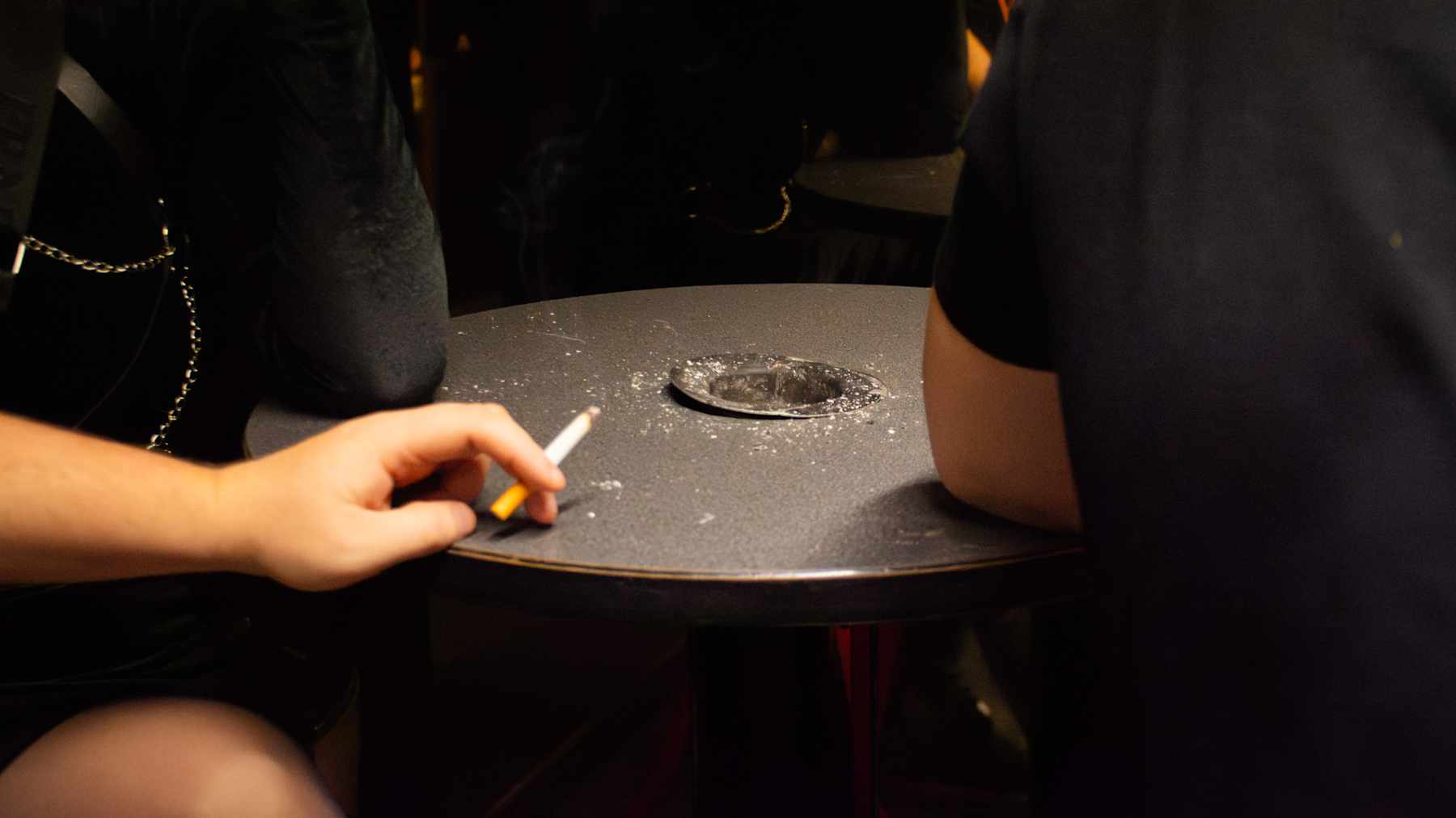 Kuvassa on Hyvinkään Hopealyhty-yökerhon tupakkakoppi, jossa asiakkaita tupakalla.