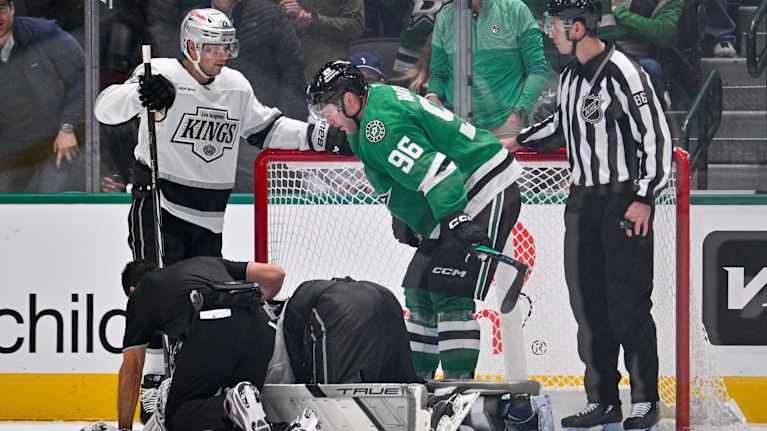 Mikko Rantanen står framåtlutad och kollar hur det är med Darcy Kuemper som ligger på isen.