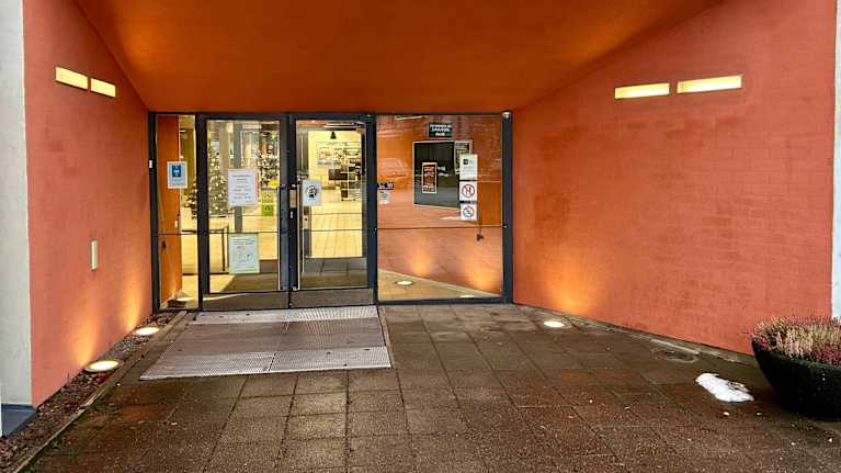 Sisäänkäynti rakennukseen, jossa on lasiovet.