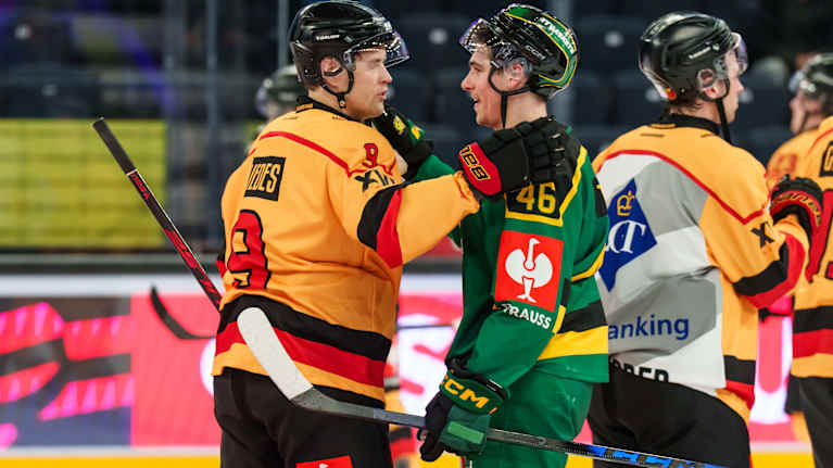 Kaksi jääkiekkoilijaa tapauttaa toisiaan olalle ottelun jälkeen mailmat käsissään.