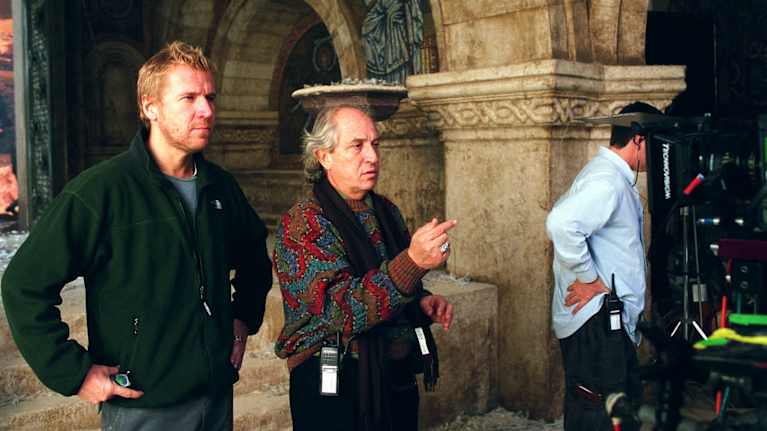 Kaksi miestä, ohjaaja ja kuvaaja, seisovat kuvauspaikalla joka muistuttaa hautakammiota.