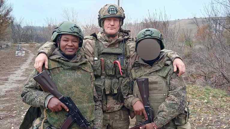 Kolme miestä taisteluasuissa.