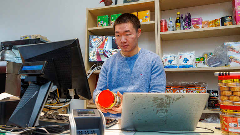 Jiafu Zhong tutkii tuotetta etnisen ruokakaupan kassalla.