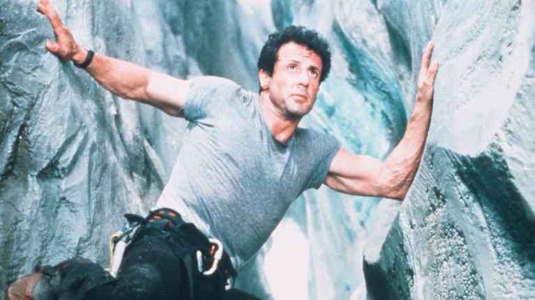 Sylvester Stallone roolissa elokuvassa Cliffhanger. Hän tasapainoilee kahde kallioseinämän välissä.