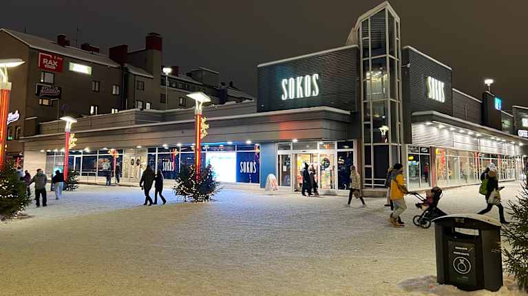 Ihmiset kävelevät talvisella kävelykadulla, jonka taustalla näkyy Sokos.