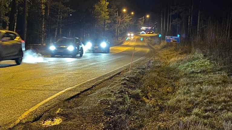Autot ajavat pimeässä tietä pitkin.