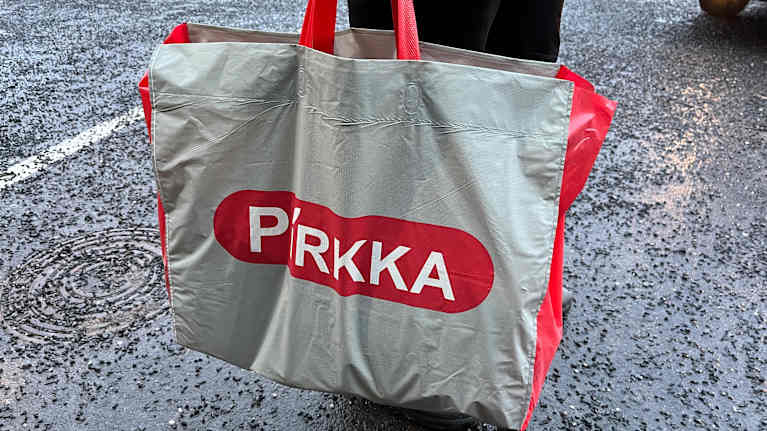 Kassi on ihmisen kädessä sateisella pihalla.