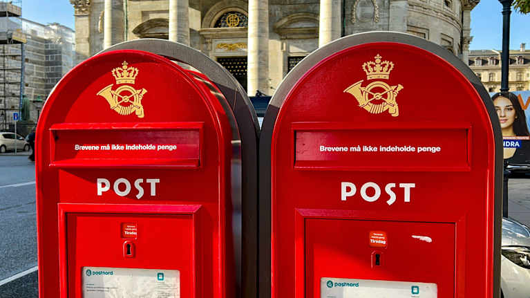 Kaksi punaista Tanskan postilaitoksen postilaatikkoa.