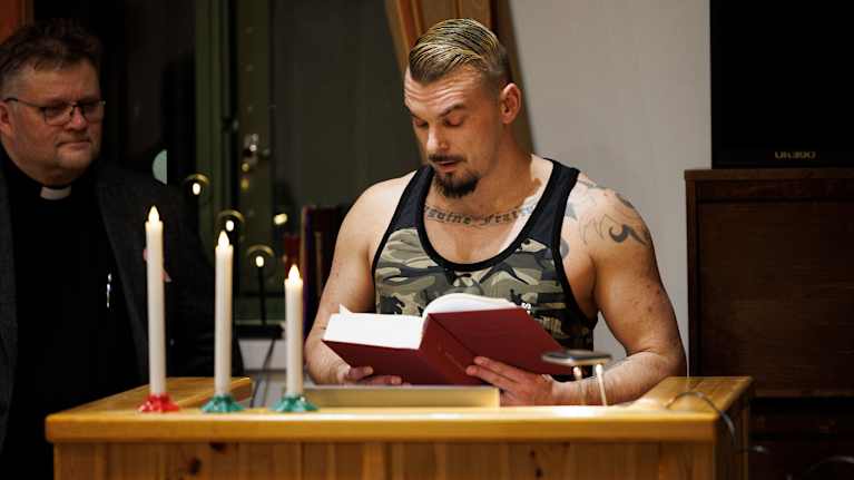 Tutkintavankina Kuopion vankilassa oleva Tino Brunfeldt lukee jouluevankeliumia. Vieressä seisoo vankilapastori Markku Virta.