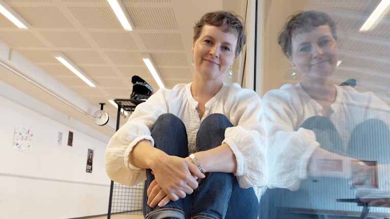 Koulunuorisotyöntekijä Tiina Lajunen istuu koulun käytävällä.