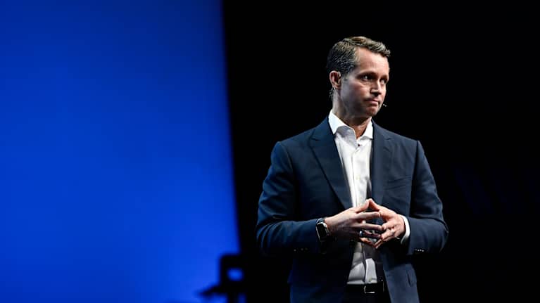 Justin Hotard seisoo puku yllään ja katsoo sivulle.