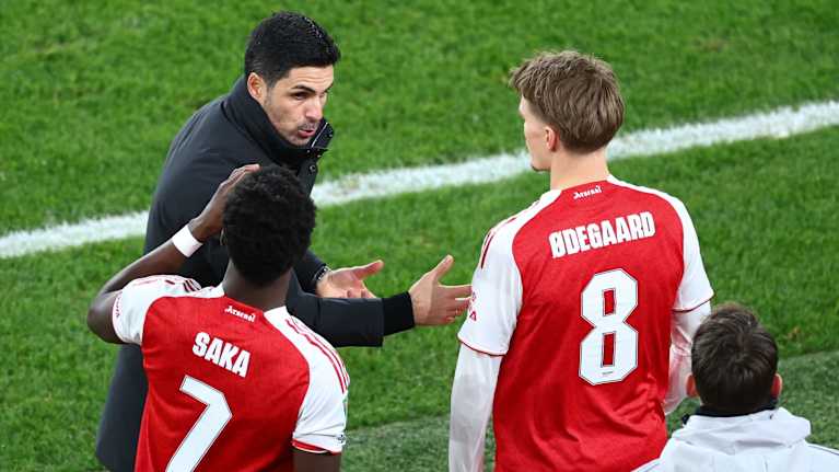 Valmentaja antaa Arsenalin pelaajille ohjeita kentän laidalla.