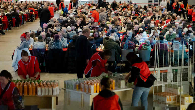 Hurstin joululounaalla olevia ihmisiä ruokapöytien ääressä.