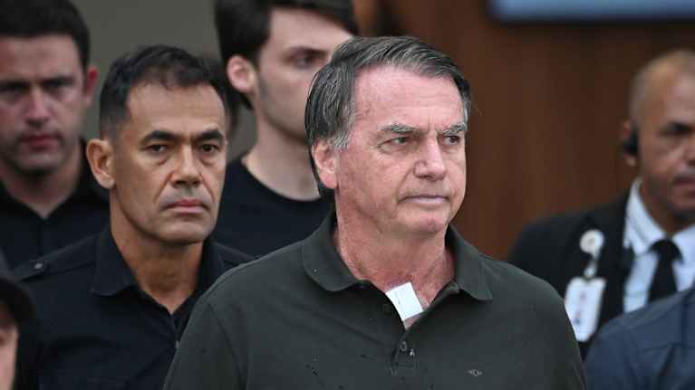  Jair Bolsonaro vihreässä pikeepaidassa, soliluiden välissä sideharso teipillä kiinni ihossa.