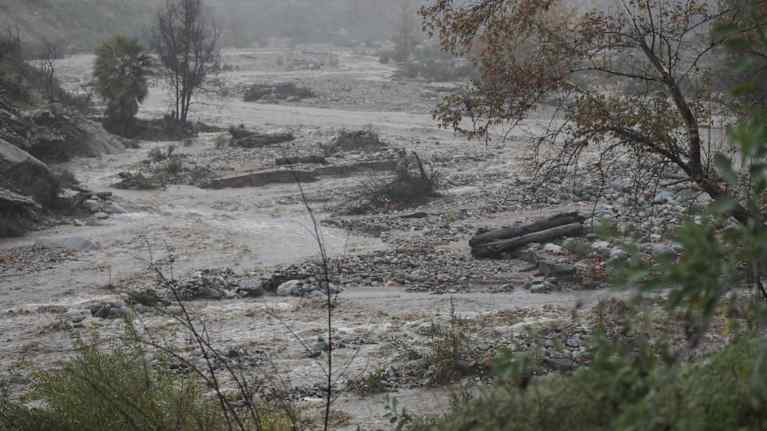 Puiden reunustama joki, sää on hyvin harmaa ja sateinen.