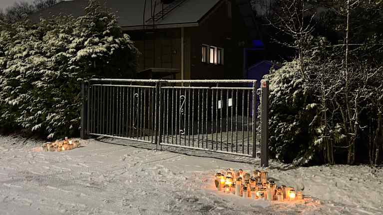 Muistokynttilöitä Pate Mustajärven kotitalon portilla.
