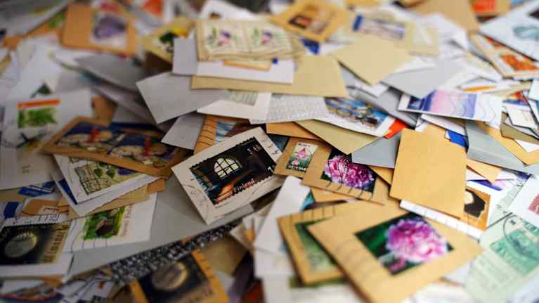 Kasa erilaisia postimerkkejä eri väreissä ja aiheissa.