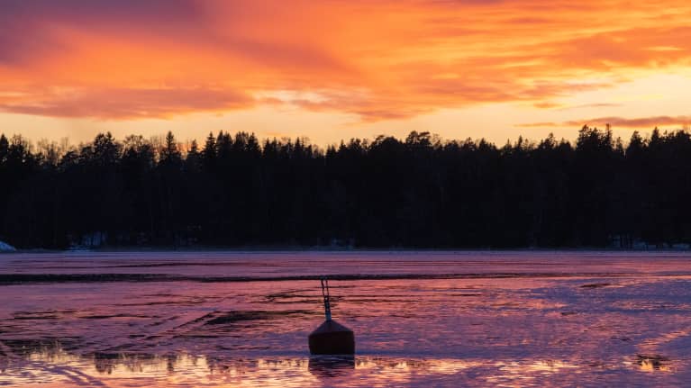 Meren jäällä lätäköitä sulaneesta lumesta.