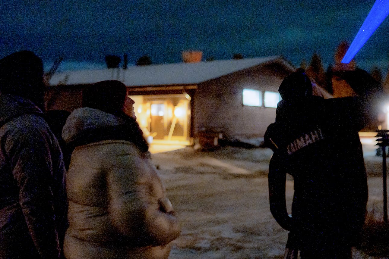 Aleksi Taipale osoittaa taivaalle kirkkaalla laserilla. Asiakkaat katselevat vierestä.