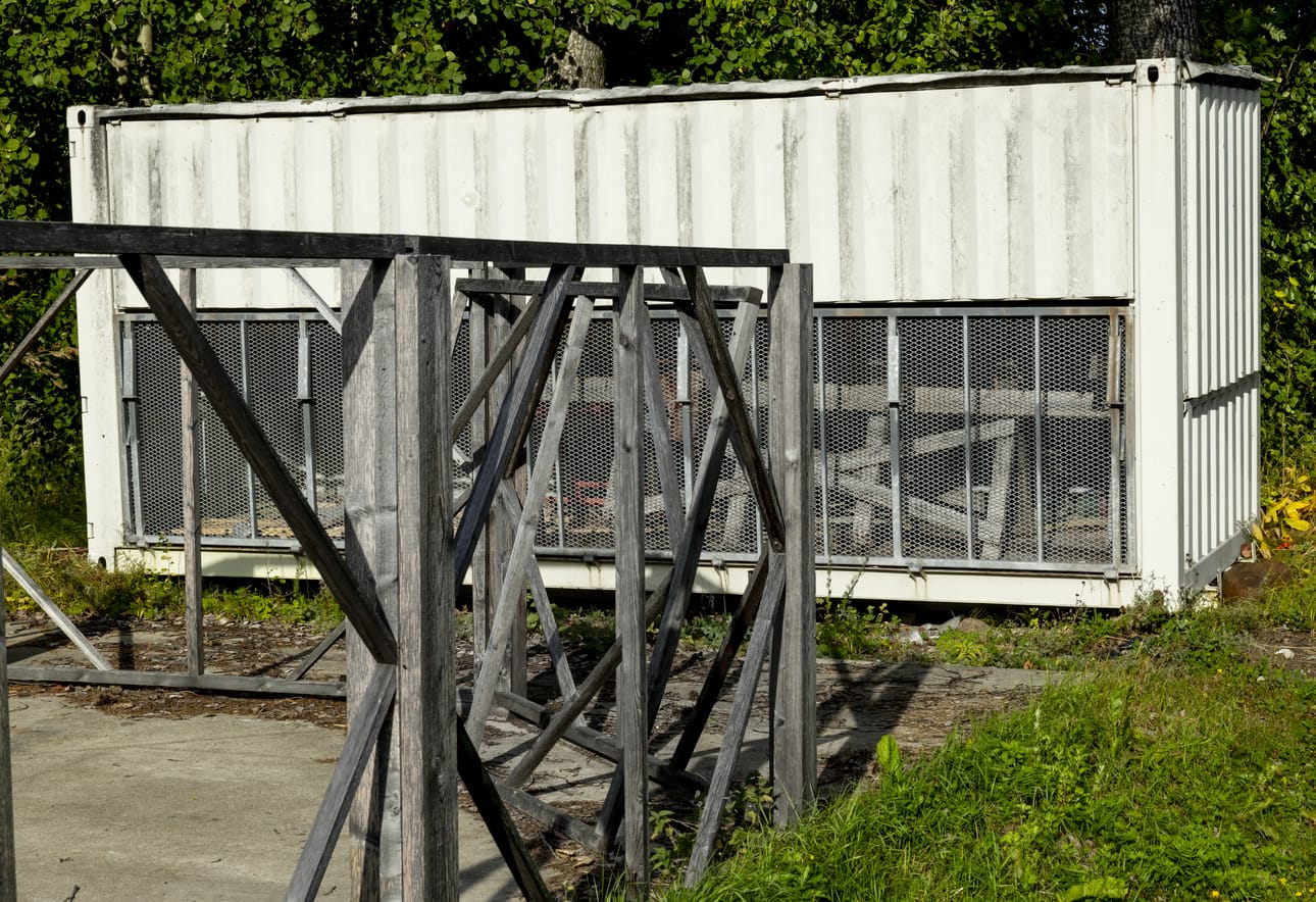 Pihalla on rakennustyömaan tavaroita, erilaisia rakennelmia sekä teräskontti.