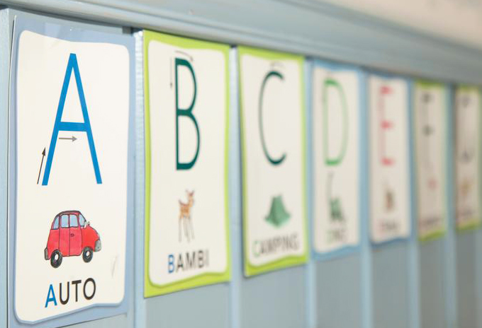 Kirjainlappuja seinässä, A auto, B bambi, jne.