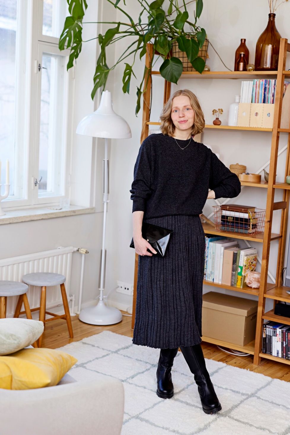 ”Tummanharmaa on hyvä vaihtoehto kovalle mustalle. En omista erikseen juhla-asuja, vaan stailaan arkivaatteet korkkareilla ja meikillä juhlaviksi.” Koko asu villaa, ostettu käytettynä 12 eurolla. Nahkabuutsit lahja valmistajalta ja käsilaukku itse tehty.