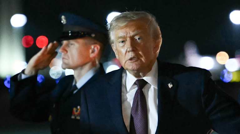 Trump lentoasemalla, taustalla sotilashenkilökuntaa.