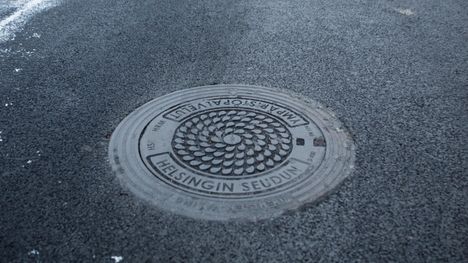 Kaivonkansi HSY:n pisaralogolla. Näitä on viime vuosina asennettu paljon, mutta Helsingissä näkyy myös vielä vanhempia malleja.