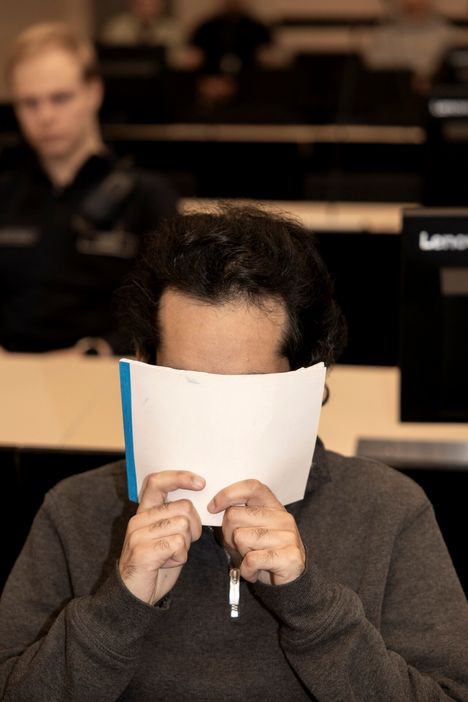 Mies peitteli kasvojaan oikeudessa.