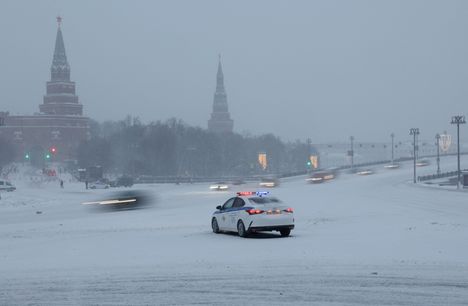 Liikennepoliisin auto kökötti tiellä sankassa lumisateessa Moskovassa perjantaina.