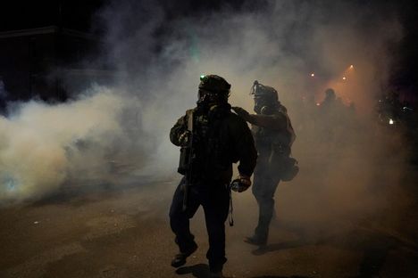 Liittovaltion poliiseja kyynelkaasupilven keskellä Minneapolisissa.