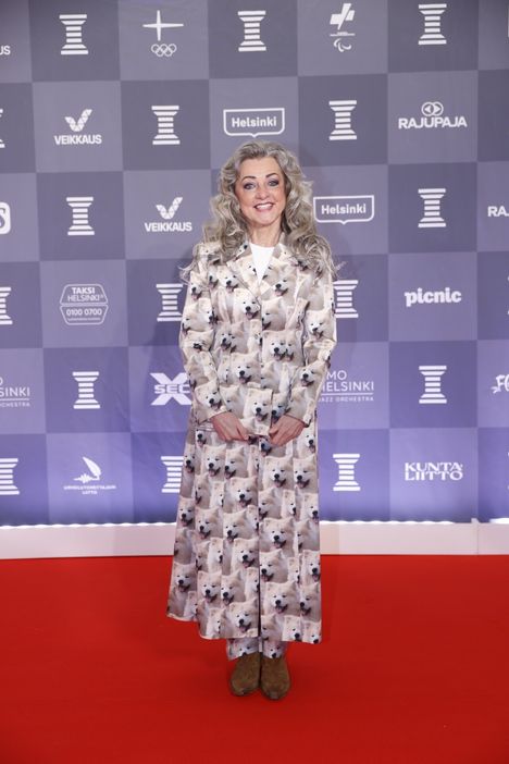 Kansanedustaja Ritva ”Kike” Elomaa (ps) saapui punaiselle matolle pukeutuneena takkiin, jota koristaa hänen koiriensa kuvat. Elomaan kädessä oleva pieni iltalaukku on nähty hänen mukanaan myös Linnan juhlissa.