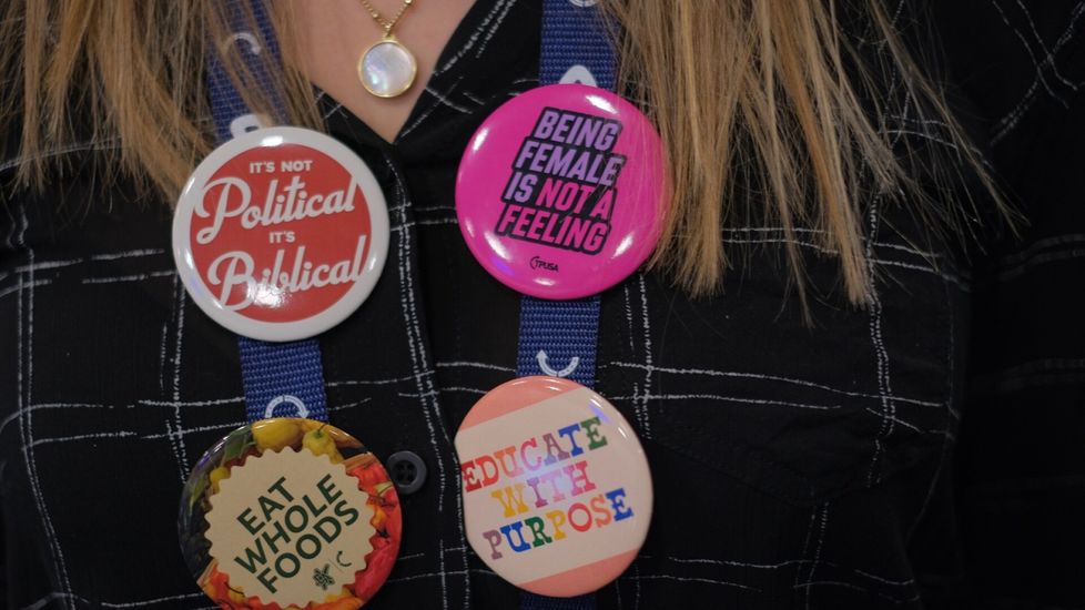 Emma Hansonin rinnassa oli kantaa ottavia pinssejä. Niissä sanottiin muun muassa, että ”naiseus ei ole tunne”. Moni Americafestin kävijä ei hyväksy sukupuolen korjaamista.