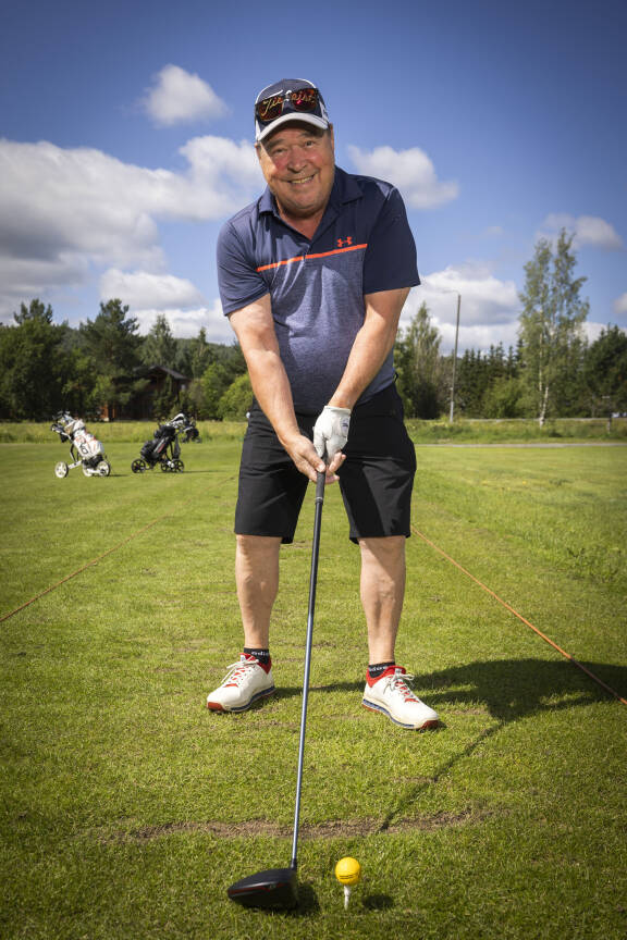 Markku Aro golf-kentällä lyömässä palloa ja poseeraamassa kameralle.