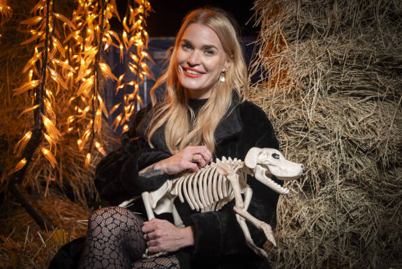 Iida Ketola poseeraa kameralle luurankokoira-lelu sylissään.