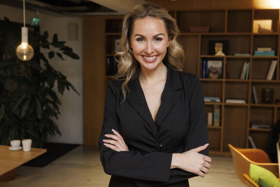 Sointu Borg hymyilee kameralle kädet puuskassa. Hänellä on yllään musta asu.