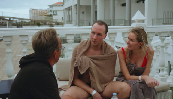 Topi ja Sointu keskustelevat kuppilassa suomalaisturistien kanssa.