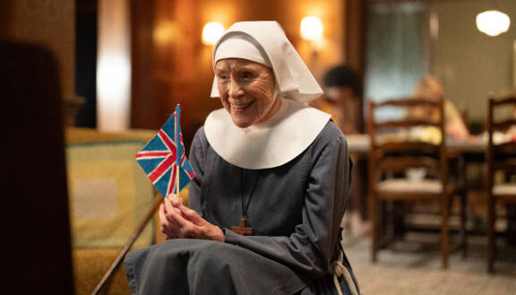 Nunna Monica Joan eli näyttelijä Judy Parfitt Britannian lippu kädessään.