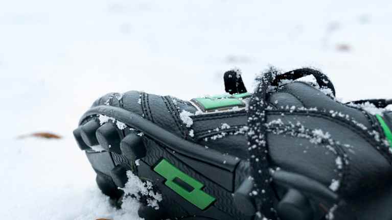 Lumisella kentällä yksinäinen lapsen jalkapallokenkä.