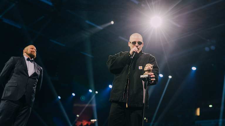 Gettomasa valonheitinten loisteessa Emma kädessään.