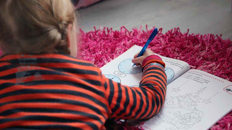 Lapsi tekee tehtävkirjaa.