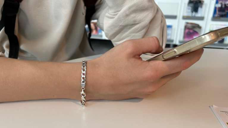 Kännykkä nuoren pojan kädessä.