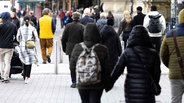 Ihmisiä kävelee kadulla syysvatteisiin pukeutuneena.