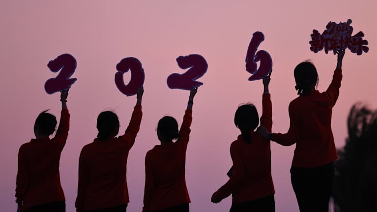 Ihmiset pitävät numeroita 2026 ilmassa.