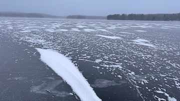 Järvi on jäätynyt ja sen pinnalle on satanut lunta.