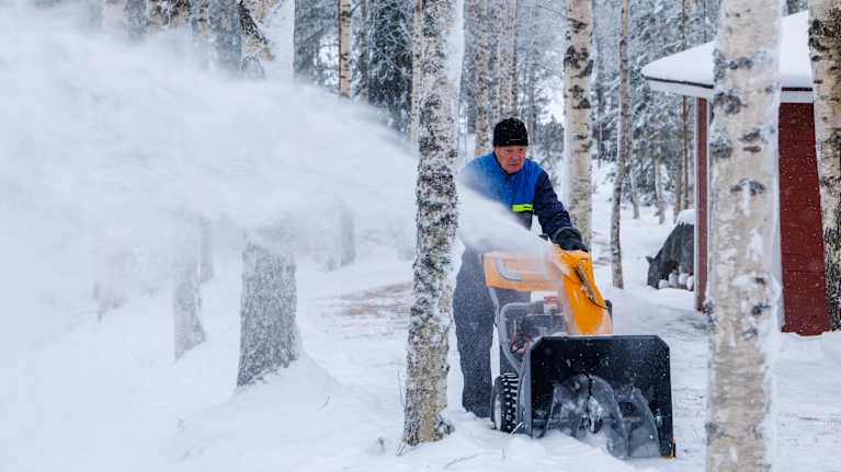 Kari Sinkkonen tekee lumitöitä lumilingolla kotitalonsa pihapiirissä Kangasniemellä.
