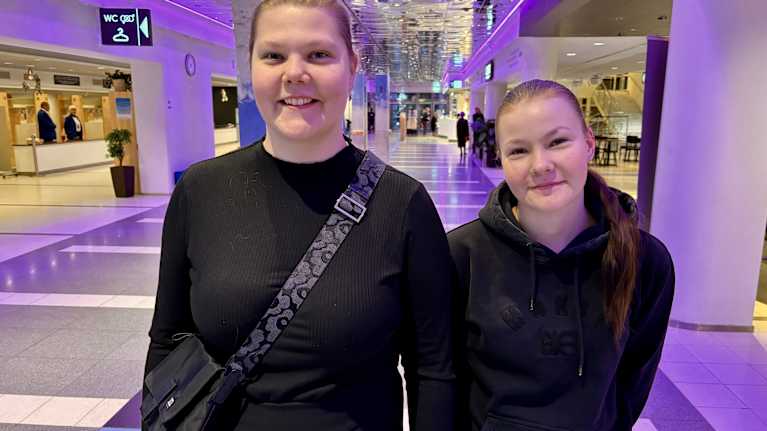 Nina Kinnunen ja Netta Kinnunen seisovat aulatilassa ja katsovat kameraan.