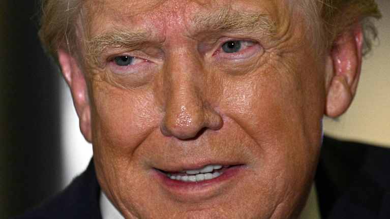 Donald Trump pratar i närbild. Han tittar åt sidan.