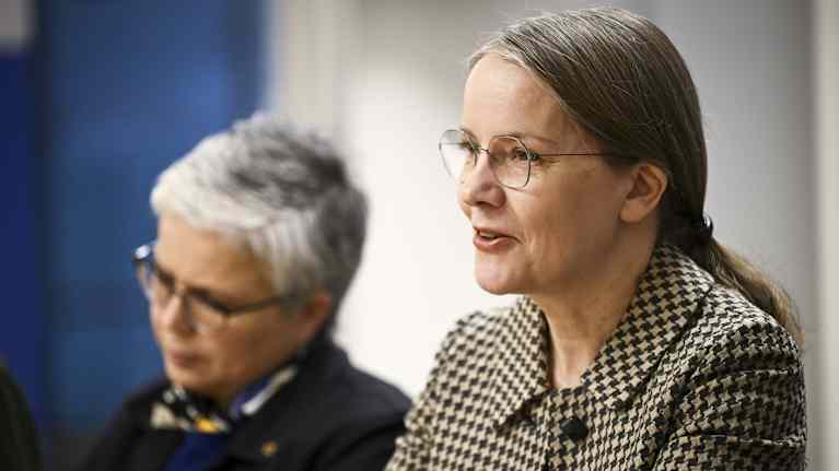 Kaksi naista tilaisuudessa pöydän takana.